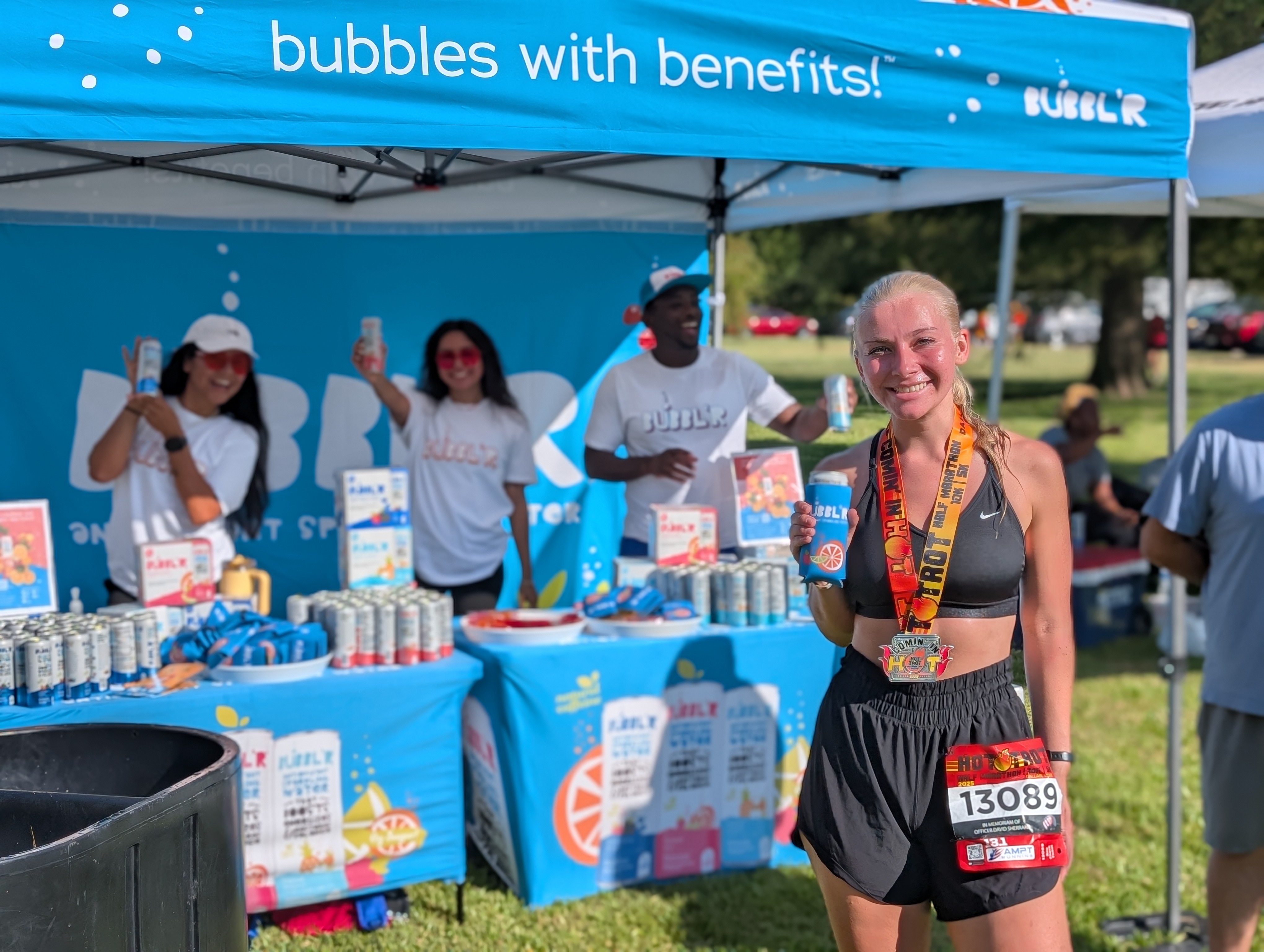 Runner holding a BUBBL'R can at a race finish tent