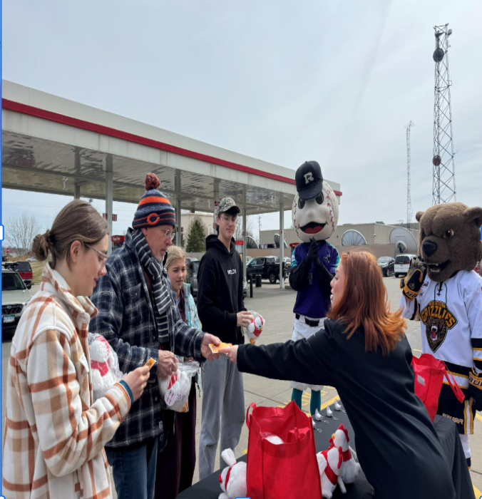 Ambassador handing a coupon and giveaway item to customers